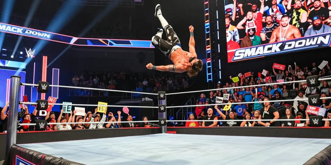 WWE SmackDown live action scene showcasing a wrestler jumping off the ropes with an enthusiastic crowd