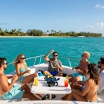 Group enjoying a yacht rental in Punta Cana, vibrant ocean background, snorkeling gear, and tropical scenery.