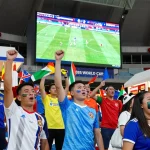 Suasana penggemar sepak bola pada jadwal piala dunia 2026 di stadion dengan bendera dan sorakan.